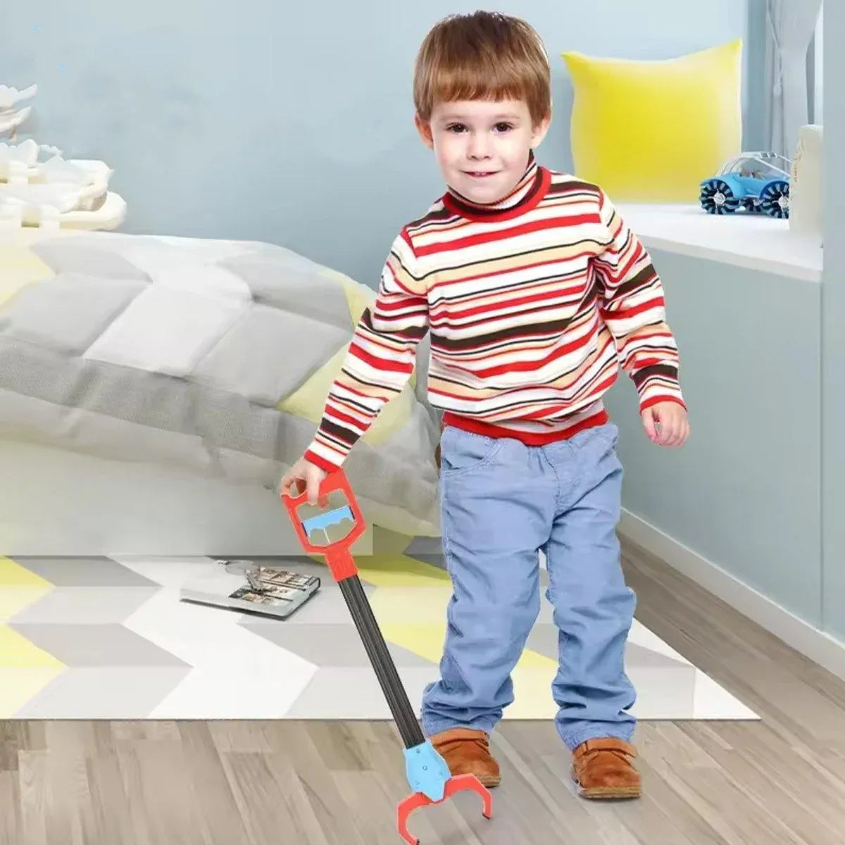 Child holding a robot claw grabber beside a sofa