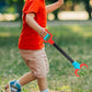 Child walking on grass while carrying a robot claw grabber