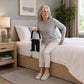 Bed rail with black grip and storage pouch shown beside a seated woman on a bed