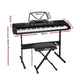 Black piano keyboard with piano keys, stand and padded stool